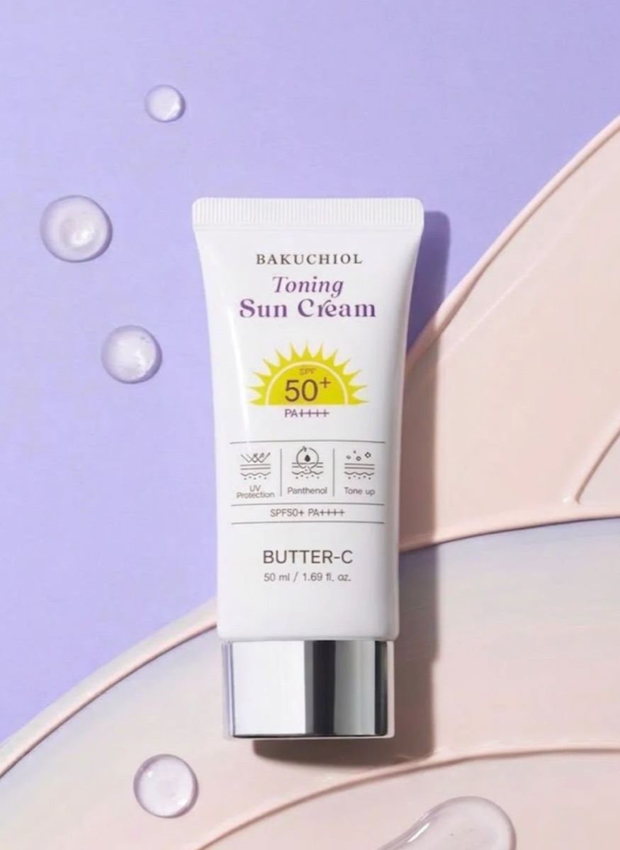 Butter-C Bakuchiol Toning Sun Cream, tuýp kem chống nắng 50 ml trên nền tím nhạt